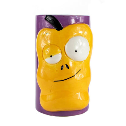 The Ceramic Monster Face Candle – Yellow resembles a cartoonish yellow apple with big eyes and a crooked mouth, similar to a whimsical ceramic mug, shown against a purple background.
