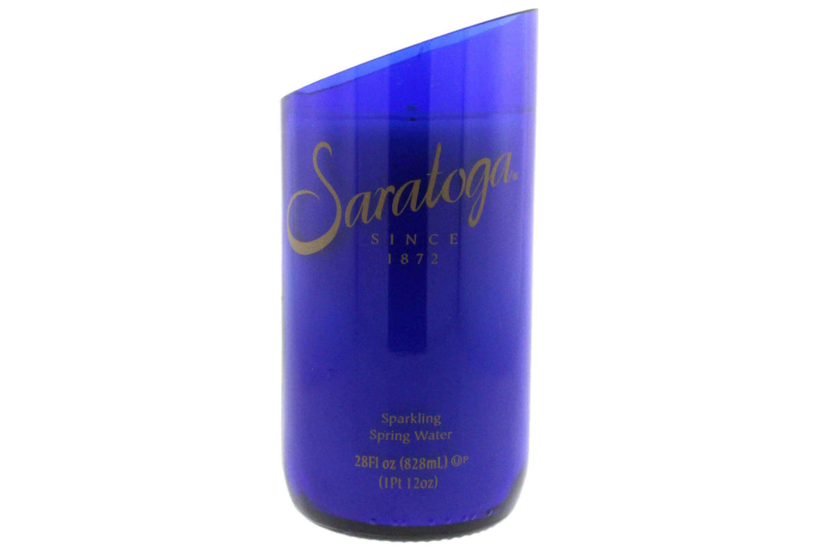 The Recycled Still Natural Spring Water Candle - Diagonal Cut is an eco-friendly candle made from a Saratoga blue glass bottle, featuring natural coconut-apricot wax and a stylish slanted top.