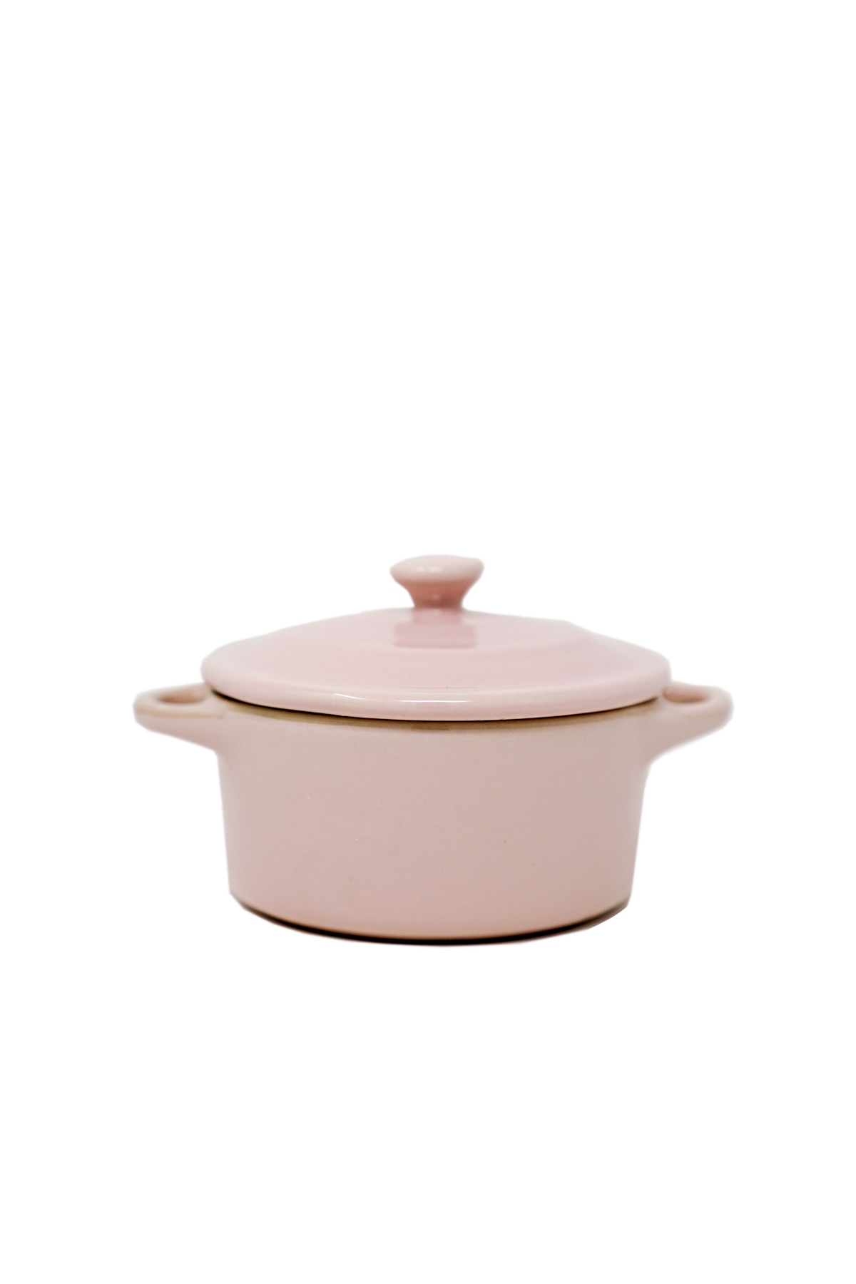 The Pink Mini Cereal Crockpot Candle, shaped like a pink ceramic casserole dish with handles and a lid, is shown against a plain white background.