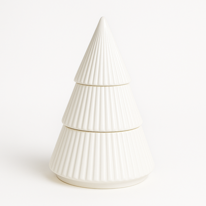 The White Ceramic Christmas Tree Candle is a ribbed, tiered ceramic candle shaped like a festive tree, crafted with all-natural wax and displayed against a plain white background.