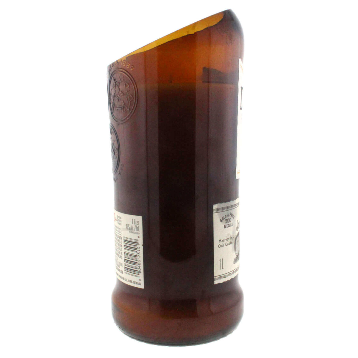 The Recycled Blended Scotch Whiskey Candle - Curved Cut features a brown glass bottle with an angled, smooth-cut top, showcasing the original label and making a unique upcycled candle holder.
