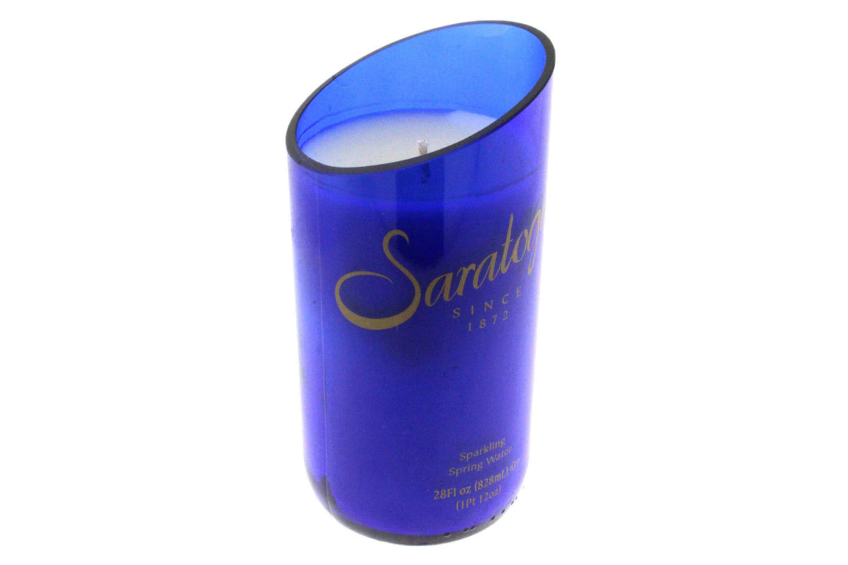 Recycled Still Natural Spring Water Candle - Diagonal Cut: A blue glass holder with white candle, gold "Saratoga Since 1872" label, eco-friendly coconut-apricot wax, and a slanted top edge for unique style.
