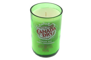The Recycled Ginger Ale Soda Candle is a soy candle in a green glass container made from a repurposed Canada Dry bottle, featuring its iconic label and wick—a unique decor piece for any space.