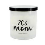 The 203 Mom White Glass Candle features a white jar with a black lid, labeled "203 mom" and "Custom Candle Co." Hand-poured, it brings a personal touch to any space.
