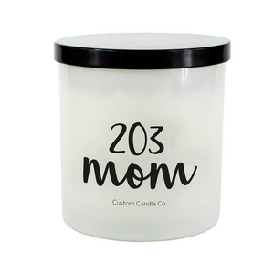 The 203 Mom White Glass Candle features a white jar with a black lid, labeled "203 mom" and "Custom Candle Co." Hand-poured, it brings a personal touch to any space.