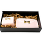 A black gift box holds two pink, bow-adorned packages with gold accents—each containing a 3D Design Handbag Shaped Ceramic Coffee Cups Set—nestled in brown crinkle paper.