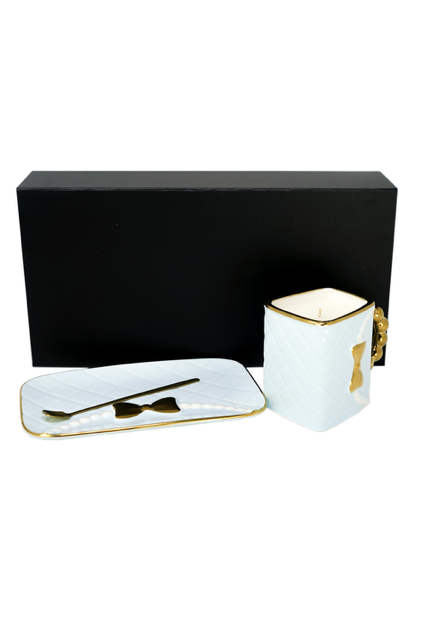 The 3D Design Handbag Shaped Ceramic Coffee Cups Set, featuring white ceramic cups with gold accents and a matching tray and spoon, is displayed in front of a sleek black rectangular box—an ideal practical decorative gift.