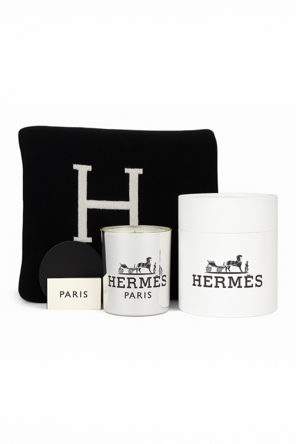 The Paris Designer Gift Set includes a black cushion with a white "H," a white Hermès candle, a Hermès box, and a "Paris" card, all elegantly arranged against a white background.