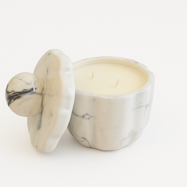 The Marble Luxe Candle features a white marble jar with a matching lid, housing a cream-colored, hand-poured soy candle with two wicks—adding an elegant touch to any space.