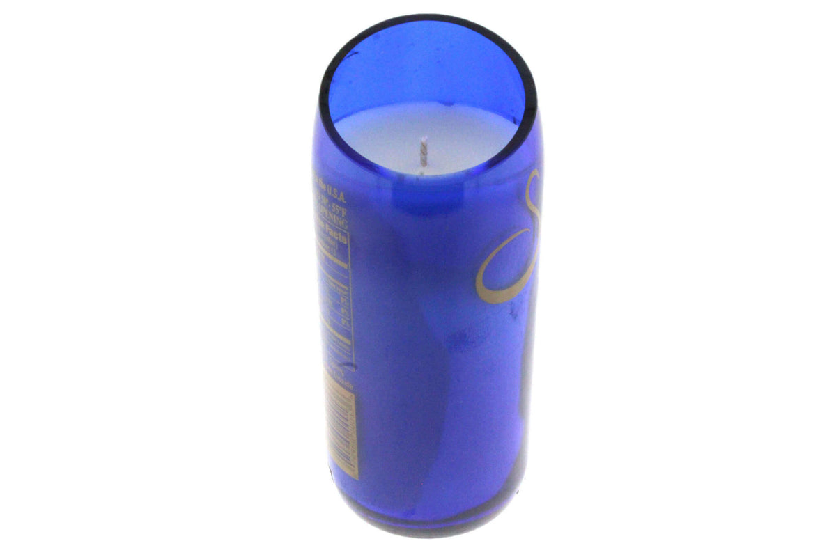 A Recycled Still Natural Spring Water Candle - Diagonal Cut, set in a white, blue glass container and crafted with natural coconut-apricot wax, viewed from above at an angle.