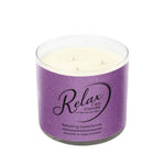 The RELAX Aromatherapy Candle 16oz – Purple Tumbler is a CBD-infused soy wax candle with lavender and sage fragrance, in a clear glass holder and a purple label, creating a soothing, calming ambiance.