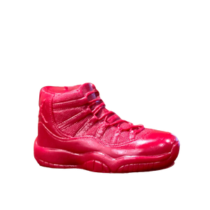 The AJ-11 Red Hightop Sneaker Candle – Large (On Backorder) is a hand-poured, all-natural wax candle shaped like a bright red athletic shoe, displayed in profile against a plain white background.