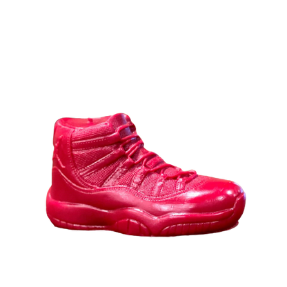 The AJ-11 Red Hightop Sneaker Candle – Large (On Backorder) is a hand-poured, all-natural wax candle shaped like a bright red athletic shoe, displayed in profile against a plain white background.