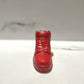 The AJ-1 Red Hightop Sneaker Candle – Large (On Backorder), hand poured with a subtle Black Ice scent, stands upright on a white surface against a light grey background.