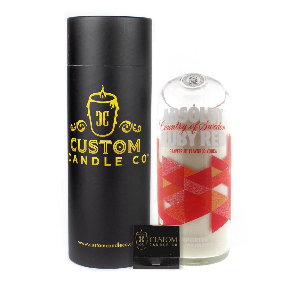 The Recycled Ruby Vodka Candle is a hand-poured natural soy candle in a recycled Absolut Ruby Red bottle, presented with a sleek black cylinder and matching matchbox.