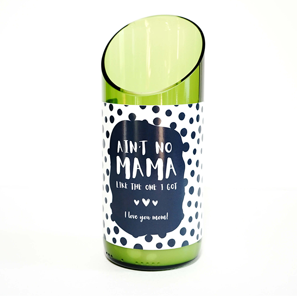 A green glass candle made from a recycled wine bottle with a slanted top and a label that says, “Ain't no mama like the one I got. I love you mom!” shown against a white background.