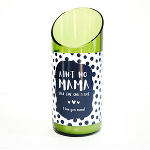 A green glass candle made from a recycled wine bottle with a slanted top and a label that says, “Ain't no mama like the one I got. I love you mom!” shown against a white background.