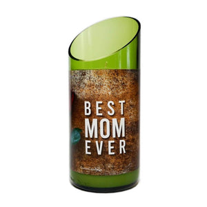 The “Best Mom Ever” Quote Candle is a green glass, hand-poured soy candle holder with a slanted top and a rustic brown label that reads "BEST MOM EVER" alongside a small floral detail.