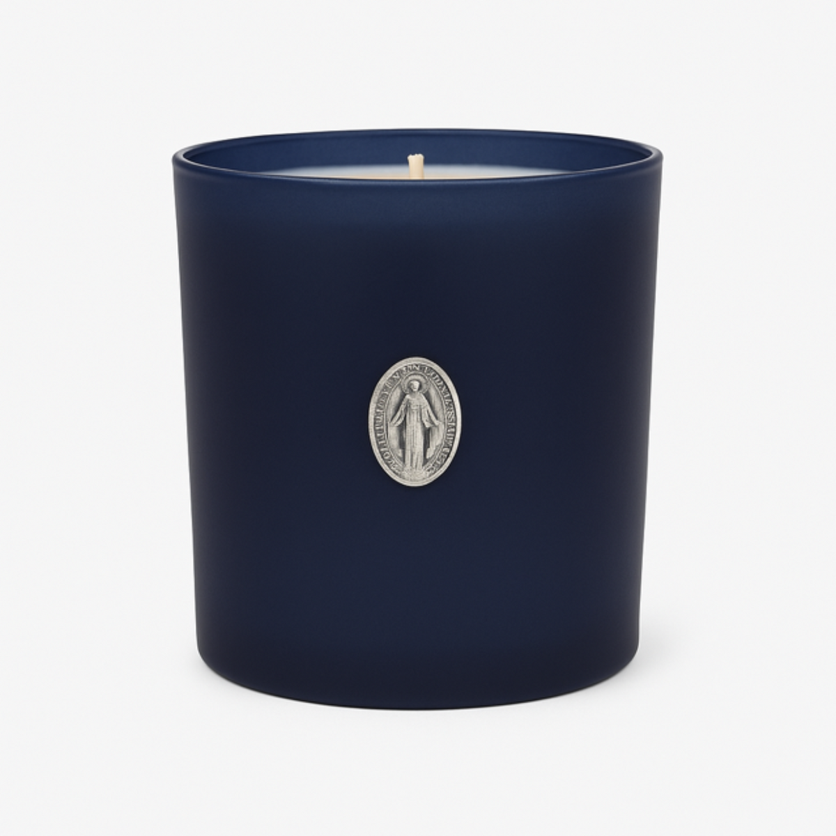 The Boxed Blessed Mother Candle is hand-poured with coconut-apricot wax in a navy matte glass, featuring a silver religious medallion, for a serene and scented experience.