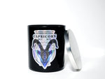 The Zodiac: Capricorn Candle is a black jar soy candle with a zodiac label, metallic lid, and date text. It includes a hidden gem inside, making it an ideal astrological gift for Capricorn enthusiasts.