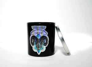 The Zodiac: Aries Candle features a black jar with a ram graphic and zodiac dates beside a silver lid on a white background—a chic soy candle ideal for astrology lovers.