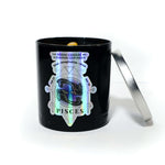 The Zodiac: Pisces Candle features a black gemstone jar with a holographic Pisces label, an open silver lid, and a Lemon Lavender scent, revealing a small object inside.