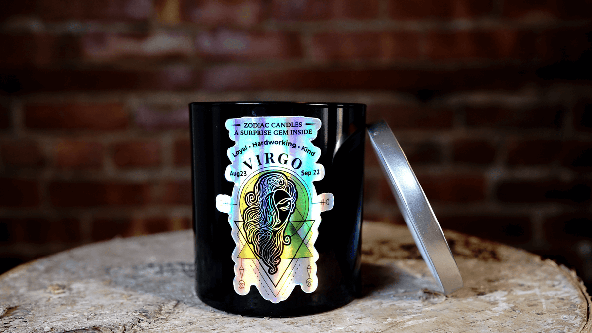 The Zodiac: Virgo Candle jar, featuring zodiac dates, sits on a wooden surface with its lid nearby. Made from natural soy, it's an ideal gift or personal relaxation pick for Virgo.