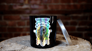 The Zodiac: Virgo Candle jar, featuring zodiac dates, sits on a wooden surface with its lid nearby. Made from natural soy, it's an ideal gift or personal relaxation pick for Virgo.