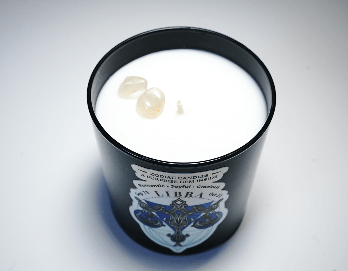 The Zodiac: Libra Candle is a black jar candle labeled "Libra," featuring three small gemstones set into the white soy wax.