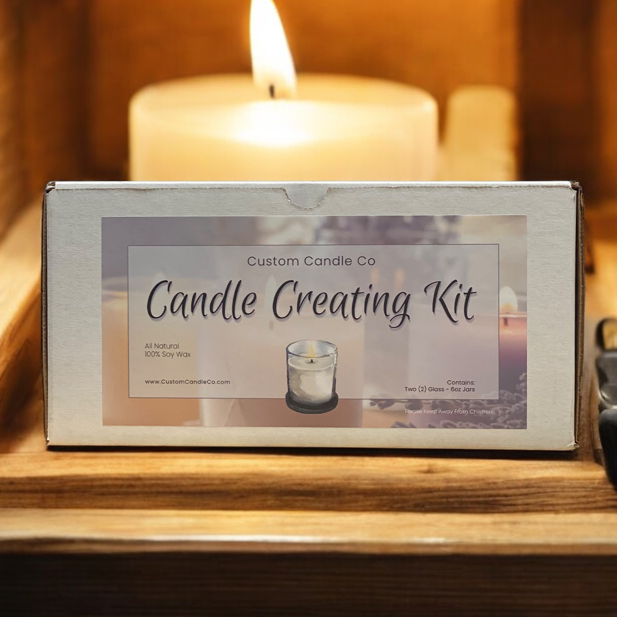A "Candle Creating Kit" from Custom Candle Co is shown on a wooden tray with a lit candle, featuring premium supplies to craft your own custom candles at home.