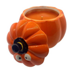 The Ceramic Orange Halloween Pumpkin Candle w/ Hat Lid is a pumpkin-shaped ceramic container with googly eyes, featuring an orange fall-scented candle inside.