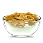 A clear glass bowl of milk and square cereal pieces, mimicking the reusable and eco-friendly Cereal Cinnamon Crunchy Candle.