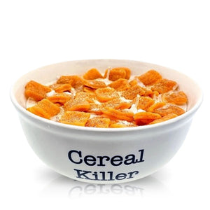 A Cereal Cinnamon Crunchy Candle is displayed in a white bowl labeled "Cereal Killer" on the front, set against a plain white background.