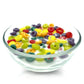 A clear reusable cereal bowl holds the Cereal Fruity Loops Candle—realistic, colorful ring-shaped "cereal" and "milk" wax—set against a white background.