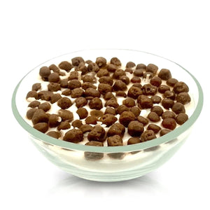 The Cereal Puffy Coco Candle features a reusable cereal bowl design, filled with white yogurt-like wax and topped with round chocolate cereal pieces for a delightful presentation.