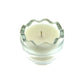 A Clear Glass Easter Egg candle made of white natural wax sits in a clear glass holder with a wavy rim, viewed from above against a white background.