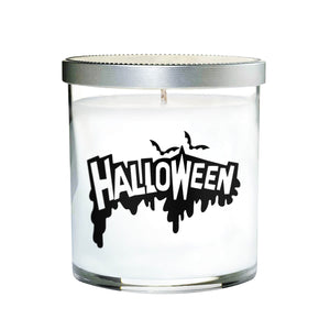 The Clear Tumbler Halloween Candle features white soy wax in a clear glass jar with a silver lid, labeled "HALLOWEEN" in bold black letters and bat graphics—perfect for adding spooky scent to your nights.