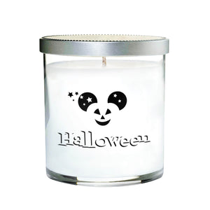 The Clear Tumbler Halloween Candle with Mouse Ears is a white candle in a glass jar with a silver lid, featuring a Mickey-shaped jack-o'-lantern and "Halloween" on the front.