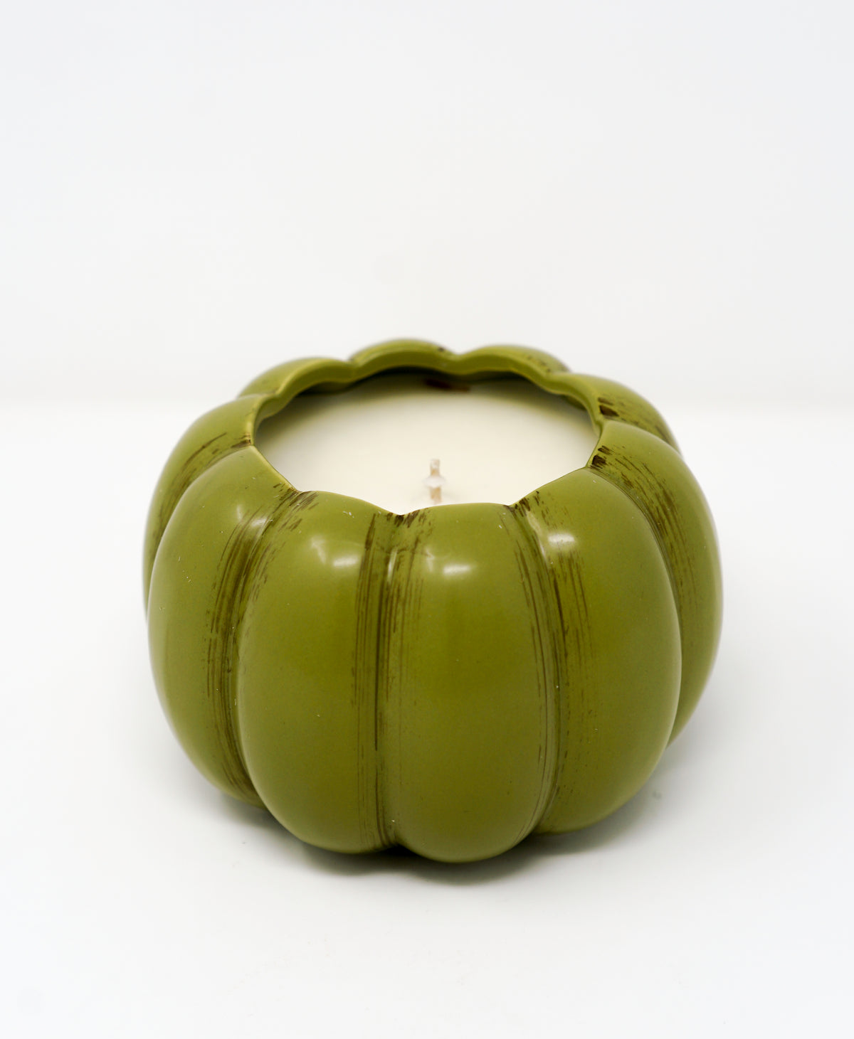 The Ceramic Pumpkin Vessel Candle features a green, pumpkin-shaped ceramic container with a white candle inside, ideal for autumn scents. Shown here against a plain white background.