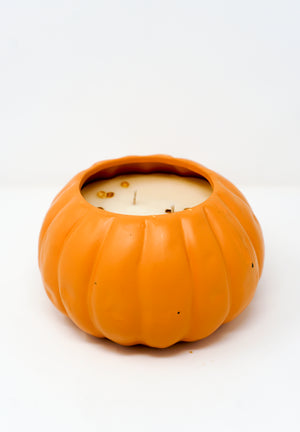A partially used white soy wax candle is housed in a pumpkin-shaped orange ceramic Pumpkin Vessel Candle, shown against a plain white background.