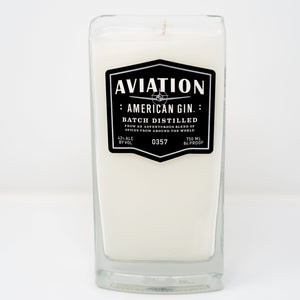 The Recycled American Gin Candle is a white natural soy candle in a rectangular glass container featuring a black label with "Aviation American Gin, Batch Distilled, 42% Alc By Vol, 750 ml, 84 Proof." Stylish and eco-friendly.