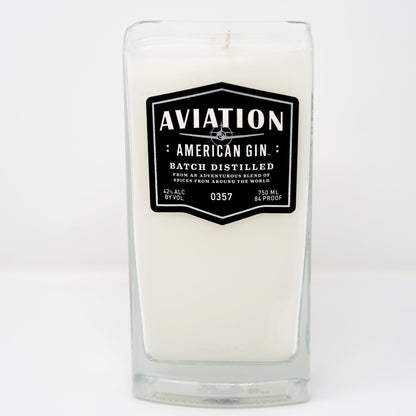 The Recycled American Gin Candle is a white natural soy candle in a rectangular glass container featuring a black label with "Aviation American Gin, Batch Distilled, 42% Alc By Vol, 750 ml, 84 Proof." Stylish and eco-friendly.