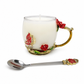 The Enchanted Rose Teacup Candle is a white scented candle in a decorative glass cup with gold and red rose accents, plus a matching metal spoon—ideal for vintage décor.