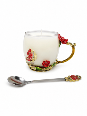 The Enchanted Rose Teacup Candle is a white scented candle in a decorative glass cup with gold and red rose accents, plus a matching metal spoon—ideal for vintage décor.