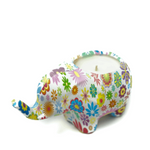 Esmeralda the Ceramic Elephant Candle features a vibrant, floral-decorated ceramic elephant holding a small soy candle on its back.