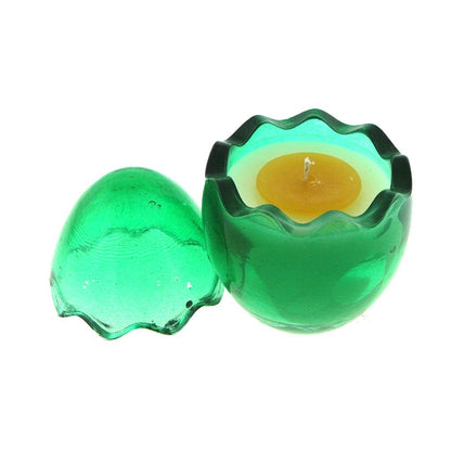 The Green Glass Easter Egg w/ Yoke features a green glass holder with a matching wavy-edged lid and contains a yellow, egg-shaped natural wax candle that brings charm and warmth to your space.