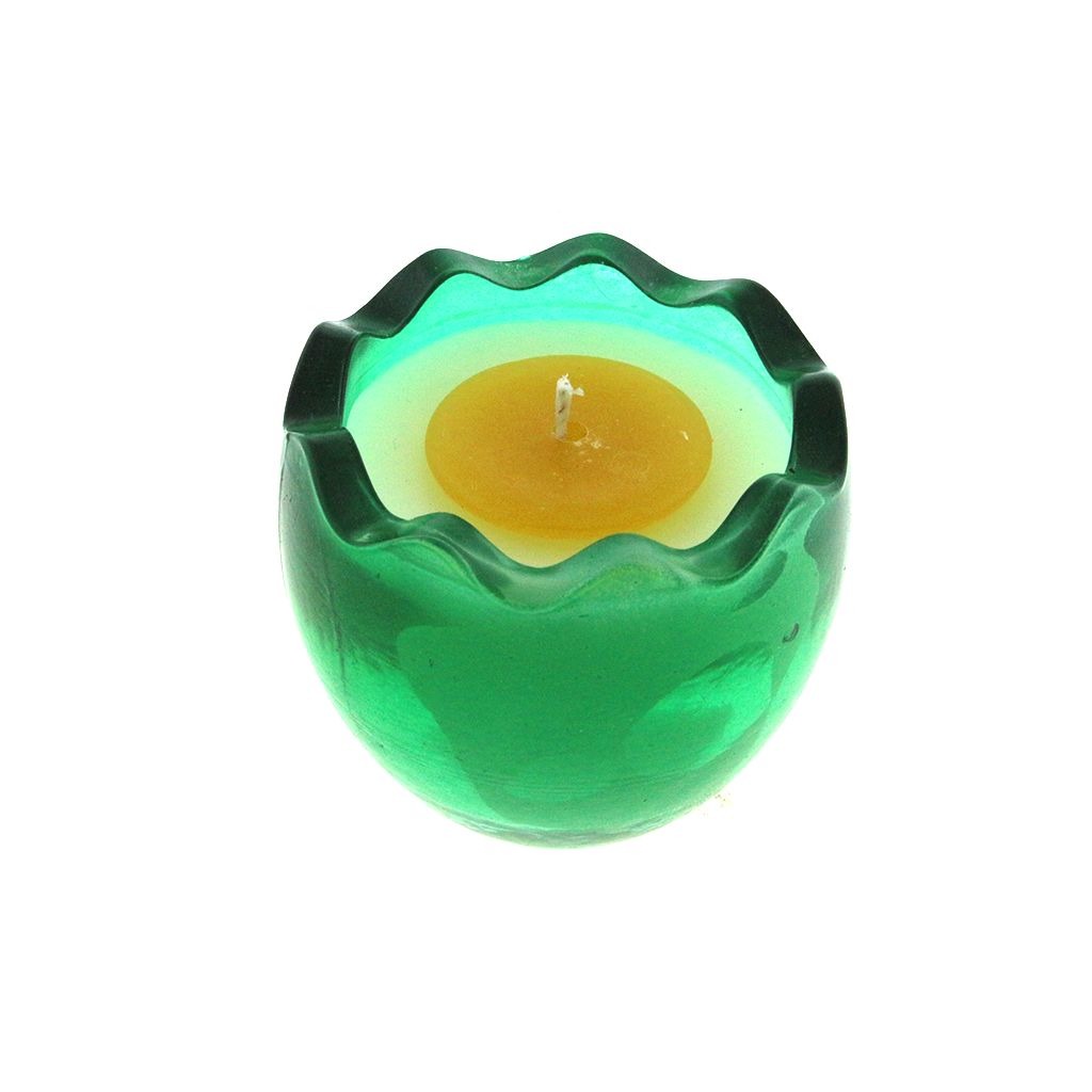 The Green Glass Easter Egg w/ Yoke is a green glass candle holder with a scalloped edge, containing an egg-shaped natural wax candle with a yellow center and white outer ring, shown on a white background.