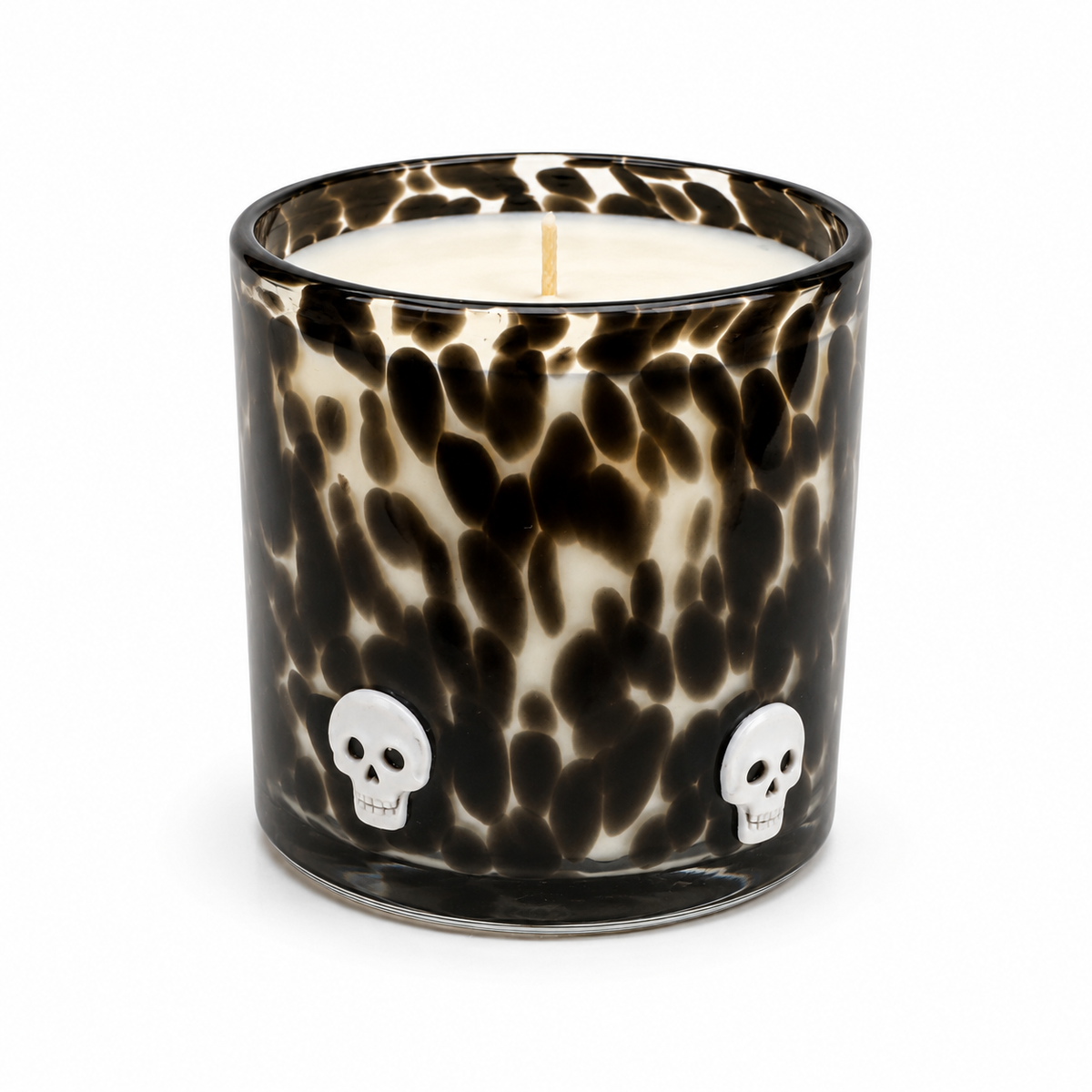 Halloween artisan candle with white skulls on a black speckled glass vessel