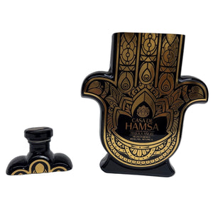 The Recycled Black and Gold Tequila Candle is crafted from a black and gold Casa de Hamsa Tequila Añejo bottle shaped like a Hamsa hand—perfect as a unique décor piece.