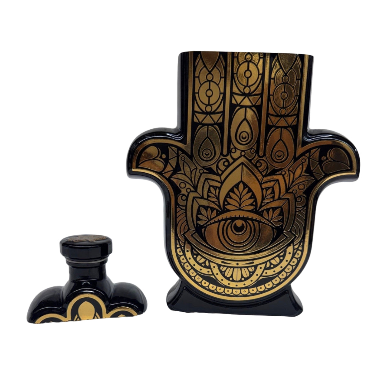 The Recycled Black and Gold Tequila Candle, featuring an intricate Hamsa hand design with eye motif, is displayed with its matching stopper.